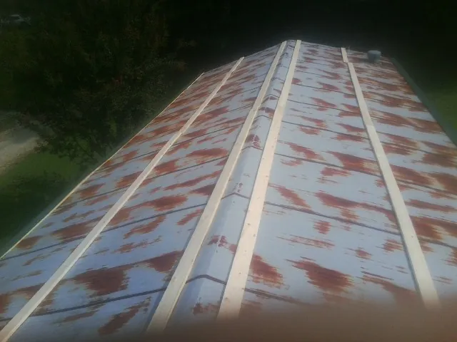 Rusted metal roof panels with new wood purlins before replacement — Storm Damage Roof Repair in Jones by Roofing Brothers
